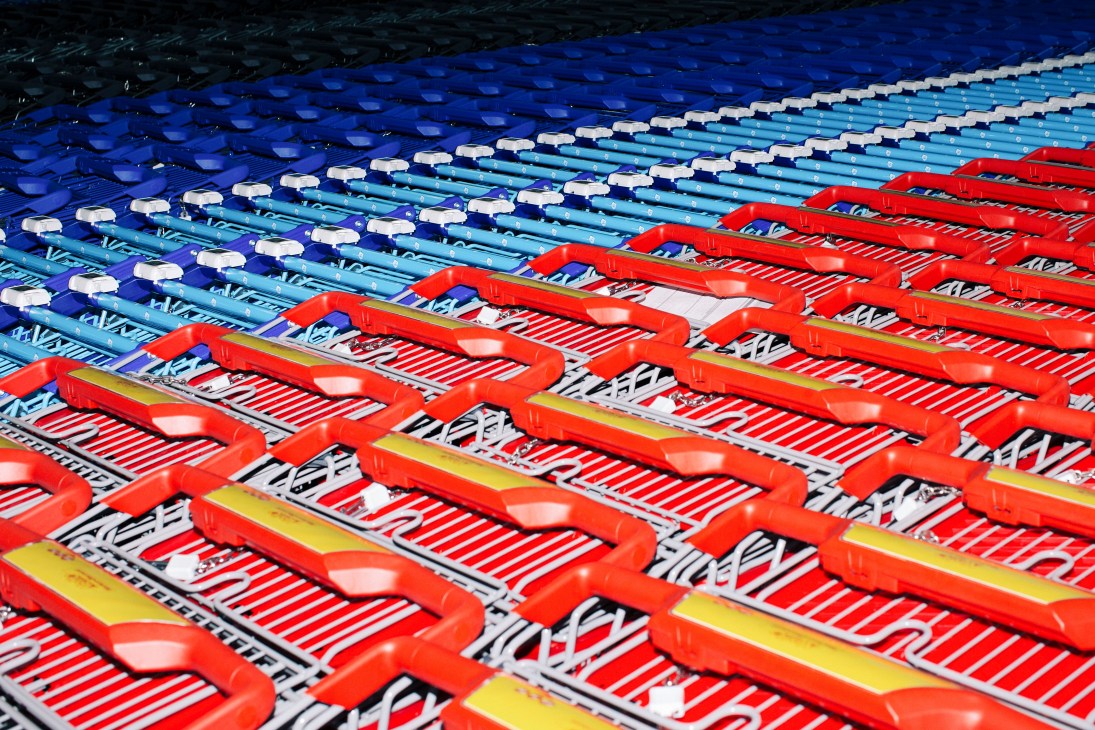Rows of red and blue shopping trolleys lined up in a warehouse ready for dispatch