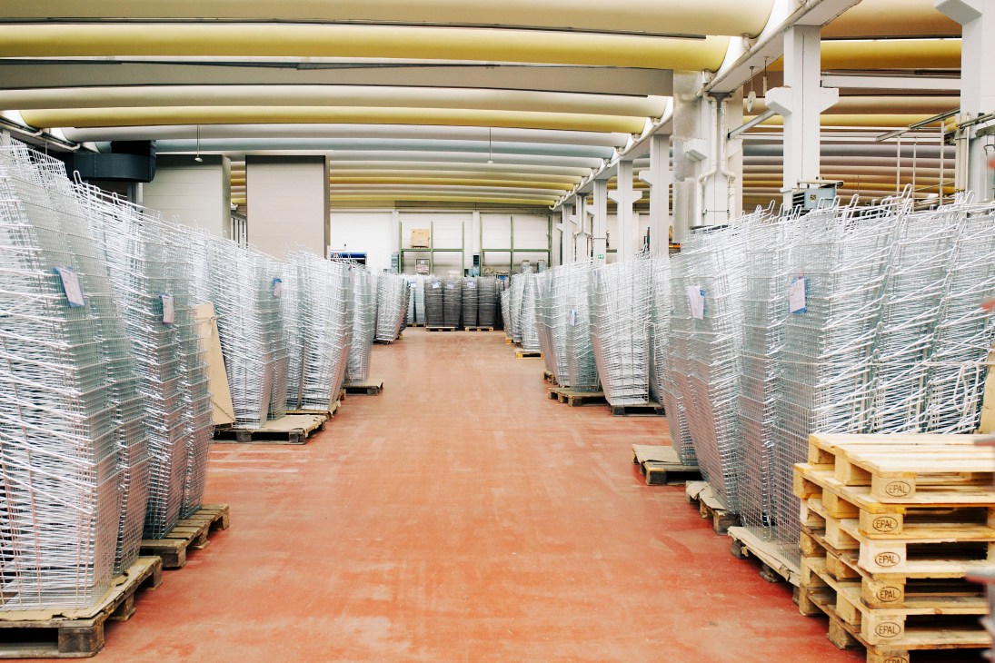 Warehouse filled with stacked wire shopping baskets on pallets ready for assembly