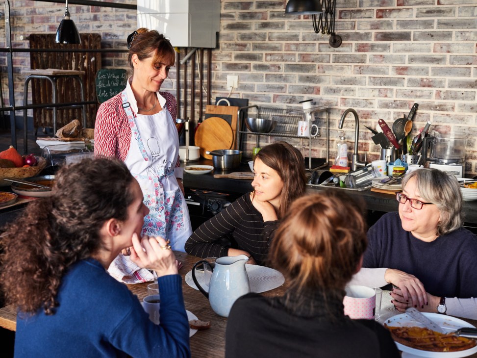 Chef Marion serves food to guests and staff in My Little Paris's office kitchen.