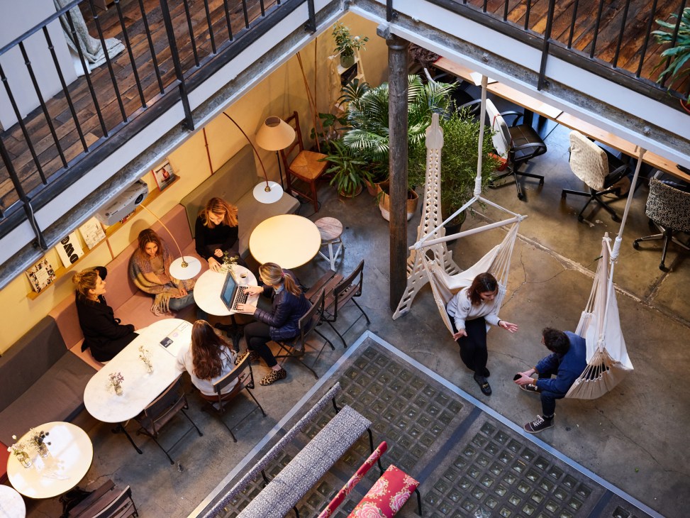 Overhead view of My Little Paris office in converted carousel factory with employees at desks, plants, and hanging hammocks.