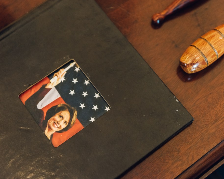 Black photo album open to show image of woman in red jacket with American flag background
