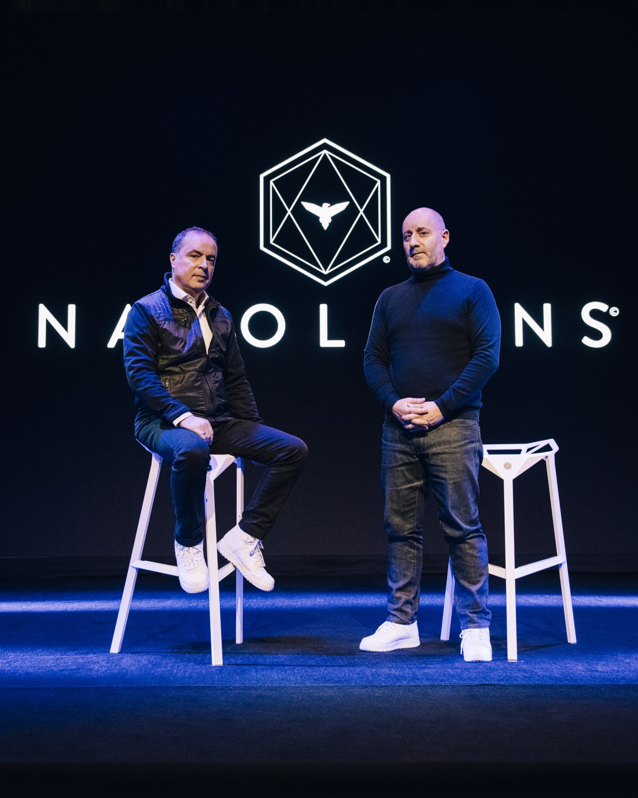 Mondher Abdennadher and Olivier Moulierac, co-founders of Les Napoleons, on stage with the organization's logo behind them.