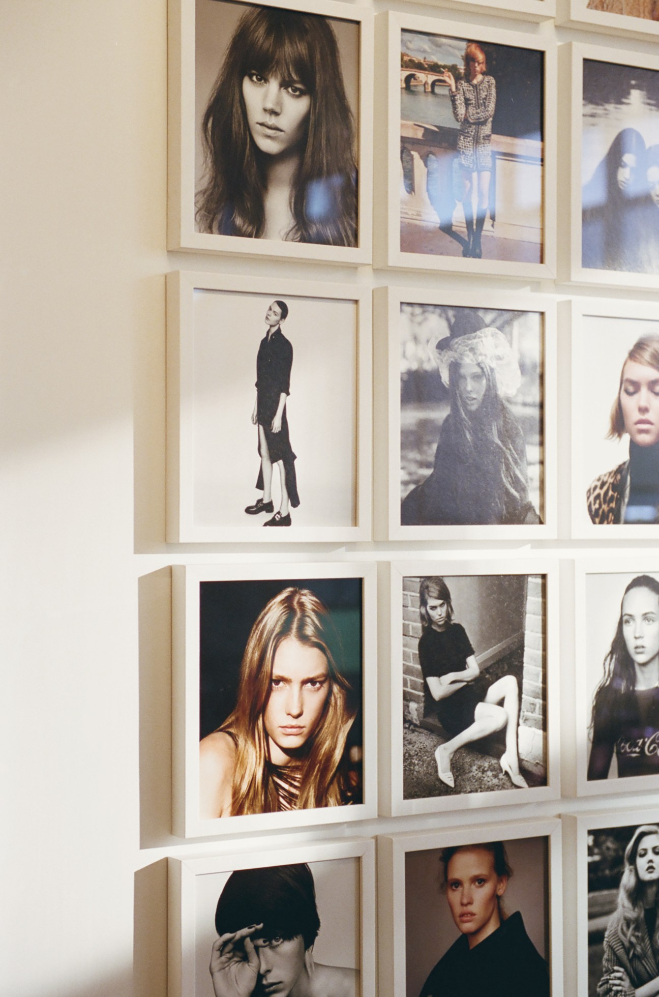 Collection of framed magazine covers and editorial photographs displayed on office wall.