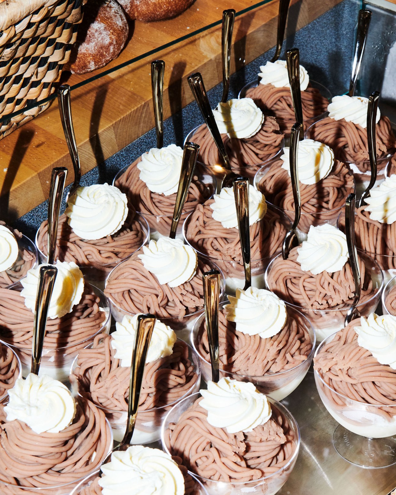 Chocolate mousse desserts topped with whipped cream and served in clear cups with spoons at Olma fair.