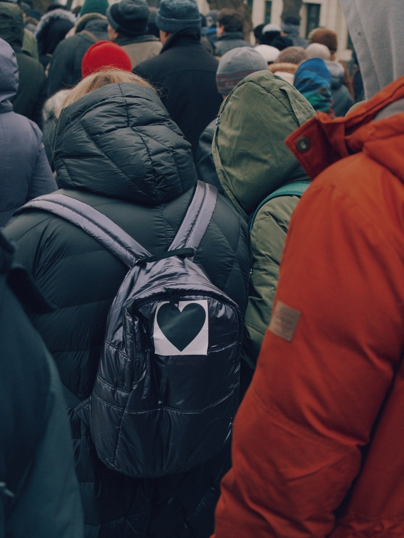 Protester wearing a black heart symbol on their jacket during a Russian demonstration.