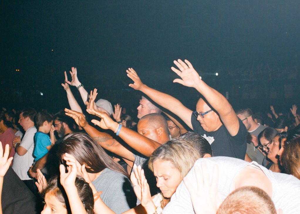 Crowd of young worshippers with raised hands during a worship music service in Nashville