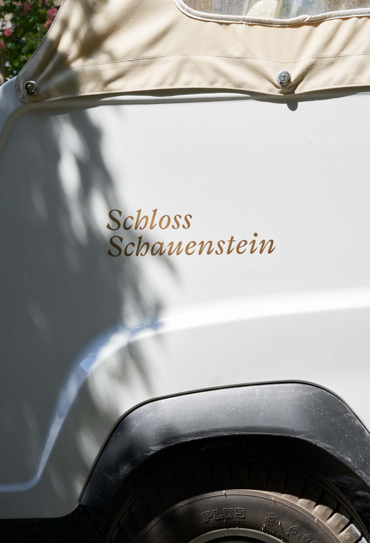 A traditional horse-drawn carriage with 'Schloss Schauenstein' written on its white side panel.
