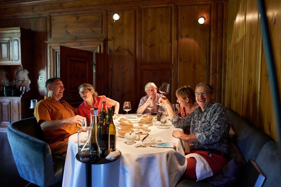 Diners enjoying an elegant meal in the refined dining room at Schloss Schauenstein restaurant