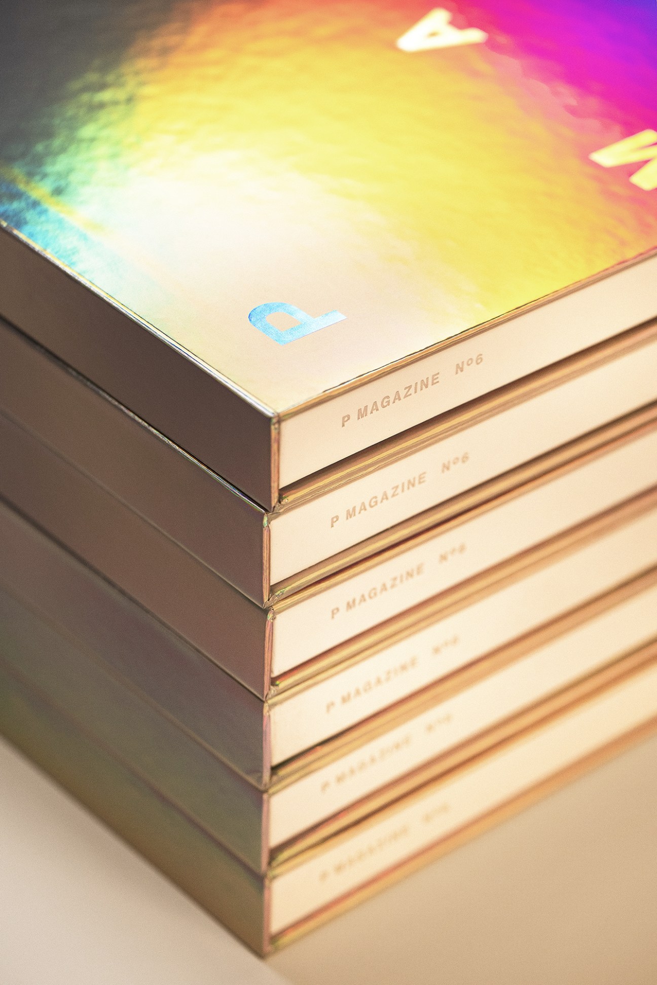 Stack of P-Magazine issues with colorful gradient cover design by Monumento.