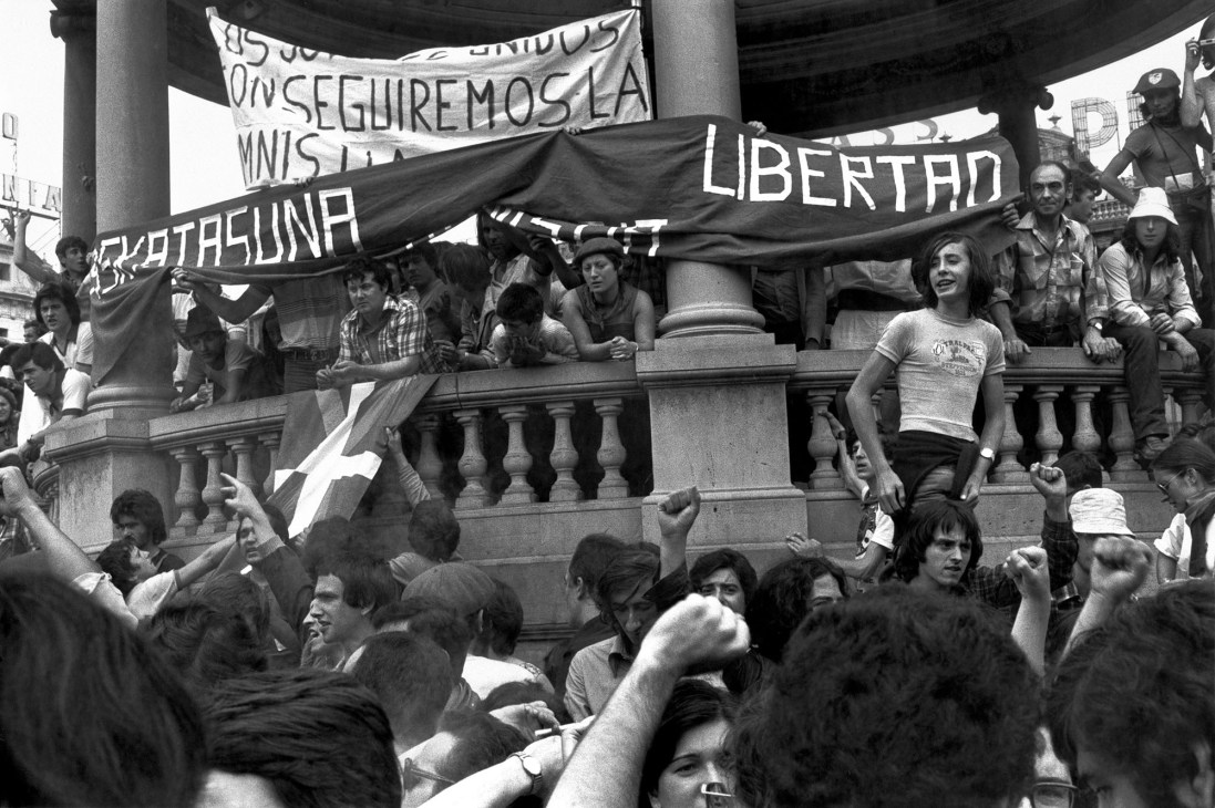 Demonstrators holding pro-independence banners and flags during a rally in Barcelona, with banners reading 'LIBERTAD' visible.