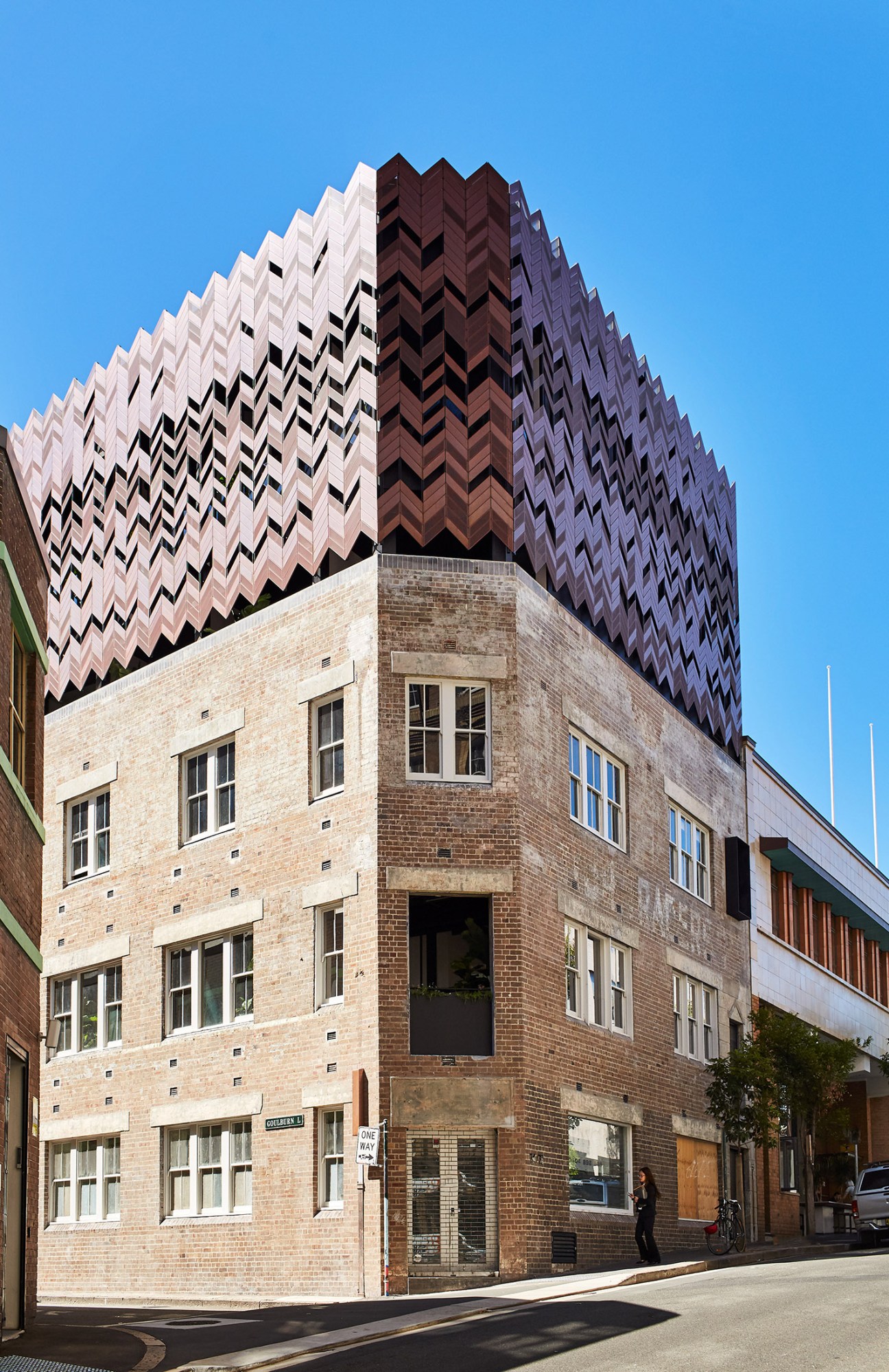 Historic brick building with distinctive copper crown-like extension on roofline in Sydney's Surry Hills.