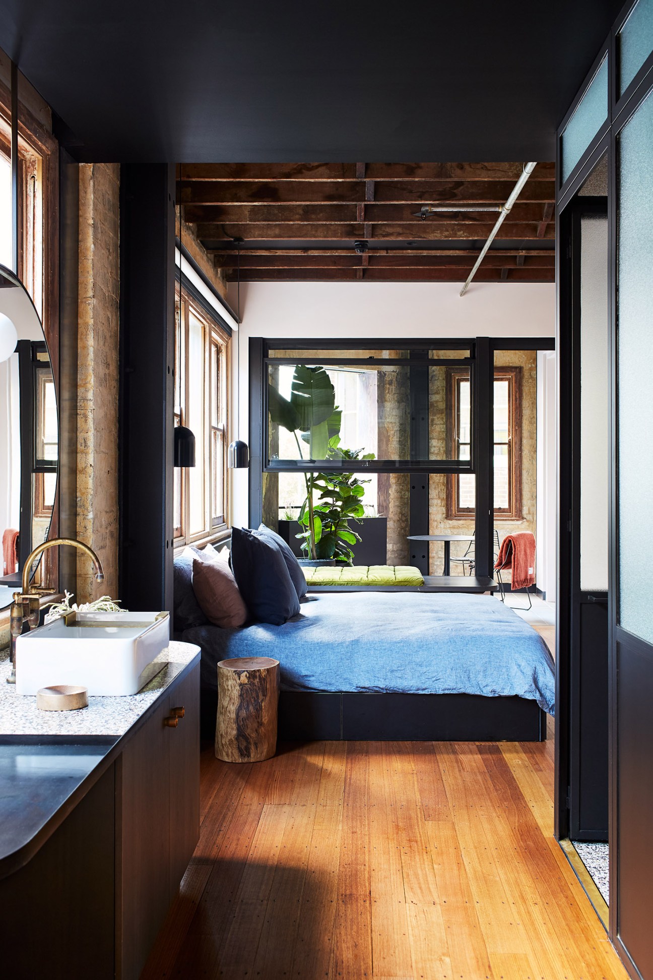 Paramount House Hotel guest room with bed, ensuite, exposed timber beams and abundant natural light from windows.