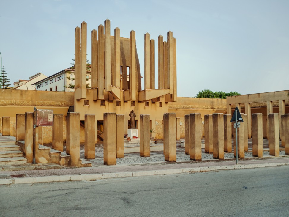 Franco Purini's Sant'Antonio da Padova church in Poggioreale Nuova with tall wooden columns and geometric concrete forms.