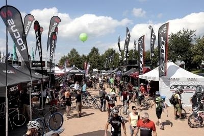 Outdoor testing area at Eurobike trade fair with vendor booths, bicycles, and visitors on a sunny day.