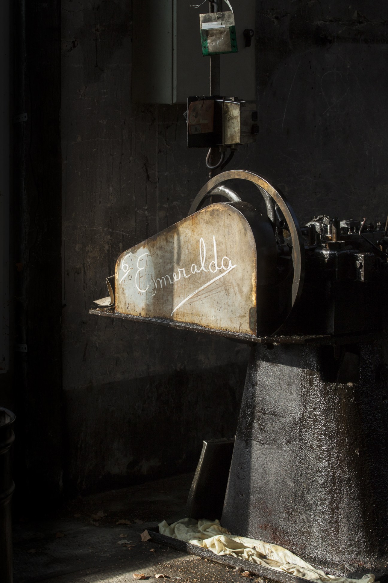 A vintage nail-making machine named Esmeralda with weathered metal components and worn lettering on its side.