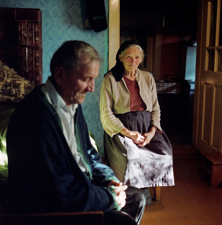 Elderly couple Nastafa and Vasile sitting together indoors after 50 years of marriage in Transylvania, Romania.