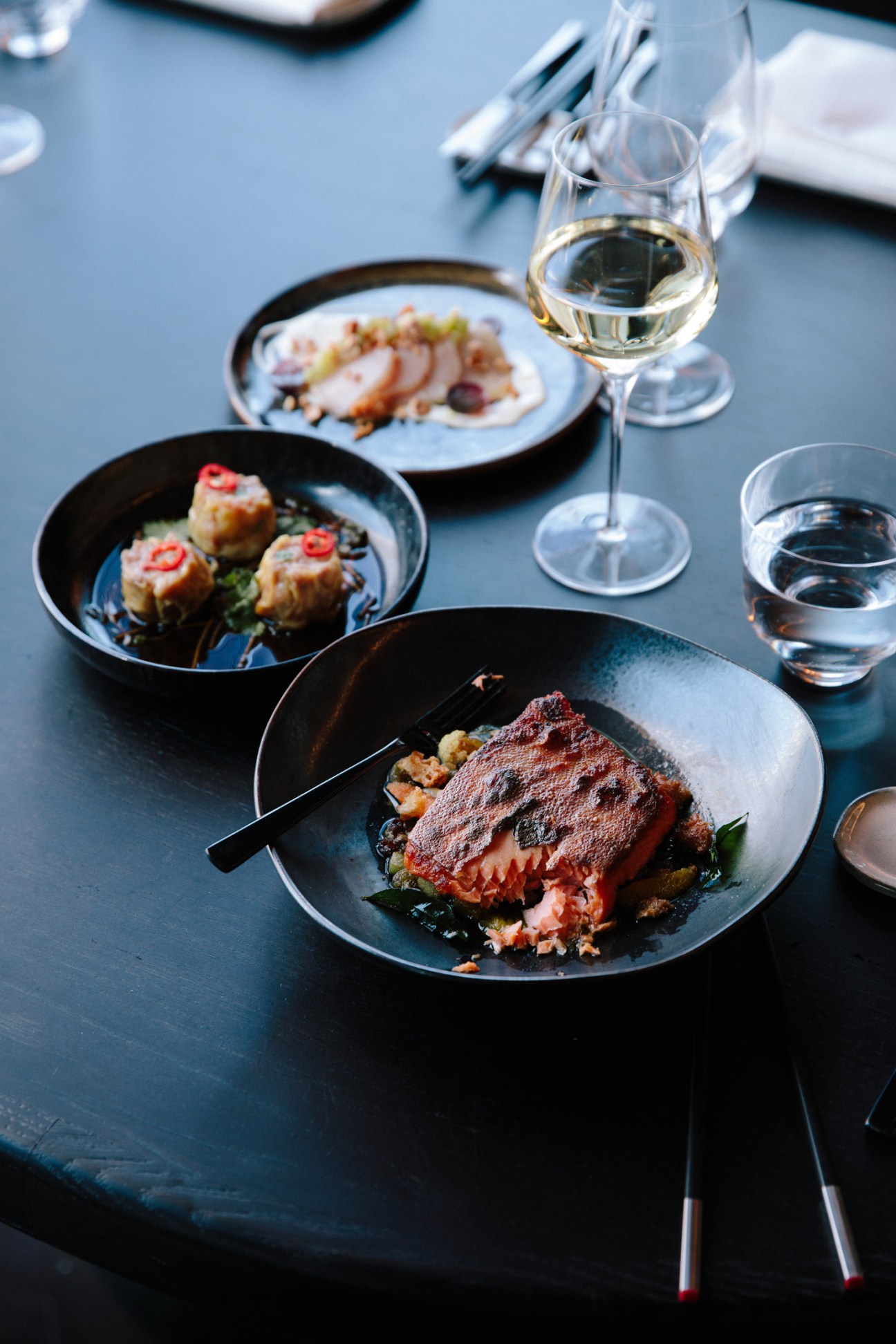 Plated arctic char with white wine and additional dishes at Wild Ink restaurant.