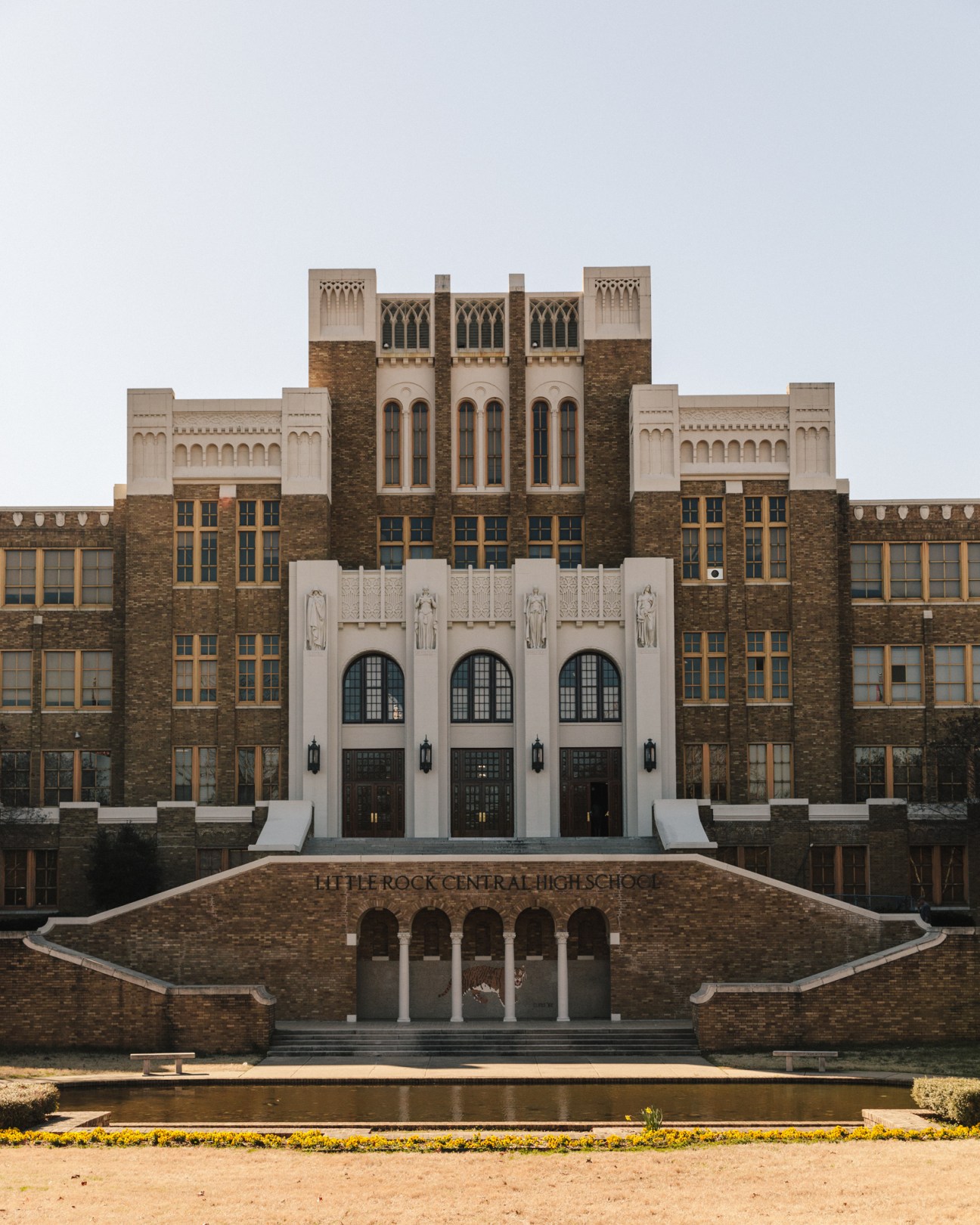 Little Rock Central High School's symmetrical brick facade with Gothic Revival tower and white stone entrance.