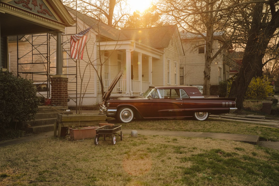 Vintage Ford Thunderbird parked in front of white colonial-style house in MacArthur Park.