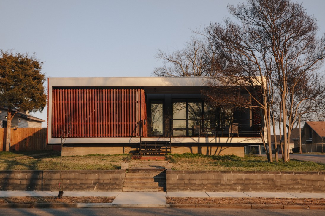 Modern residential home with red corrugated metal siding and black windows in MacArthur Park.