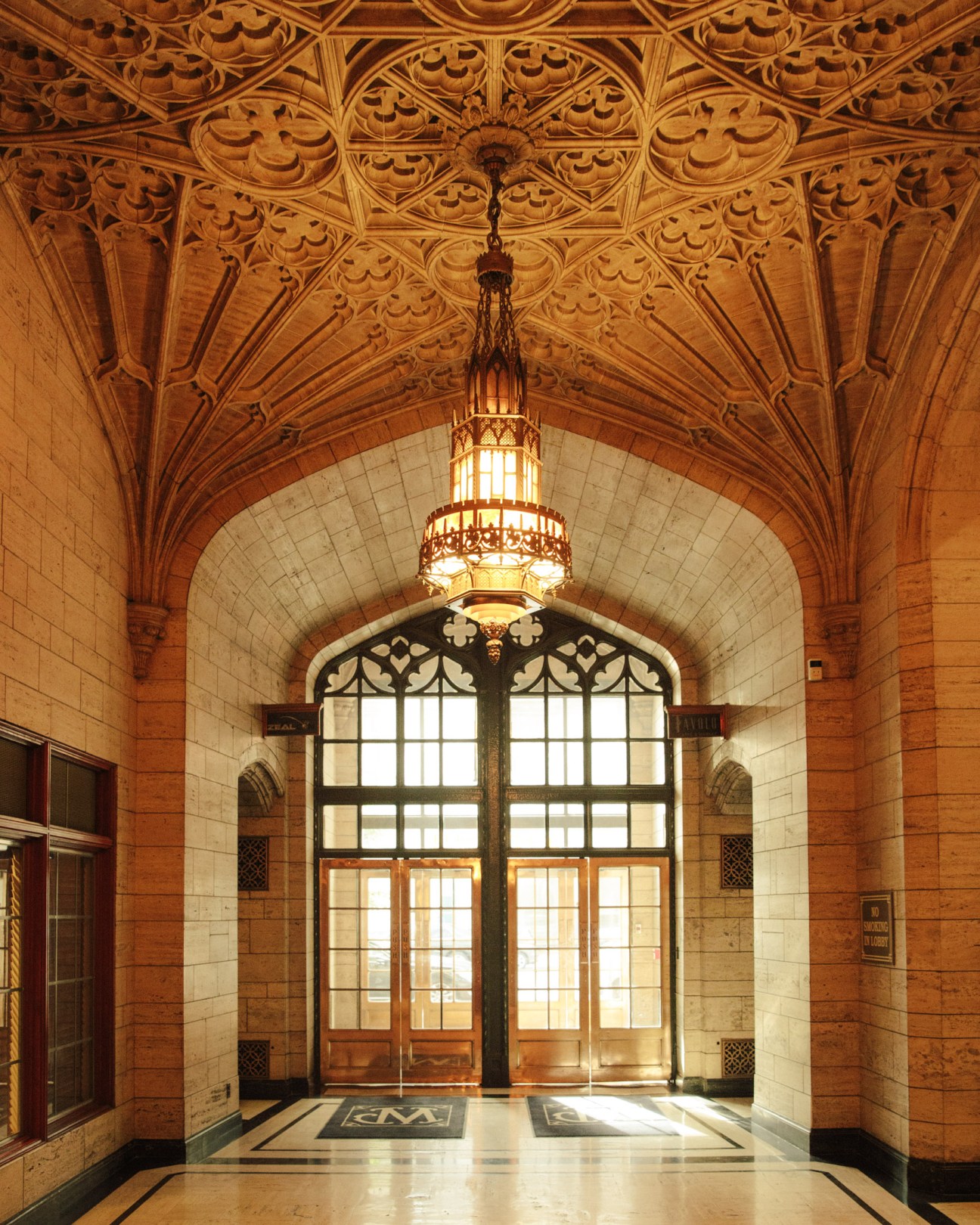 Ornate Gothic-style travertine ceiling and decorative pendant light in the Philtower Building lobby.