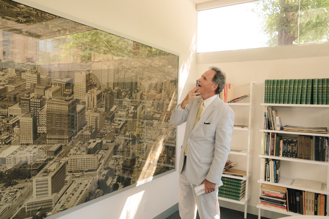 Architect Ted Reeds in seersucker suit gazing at Gothic-style travertine ceiling in ornate building lobby