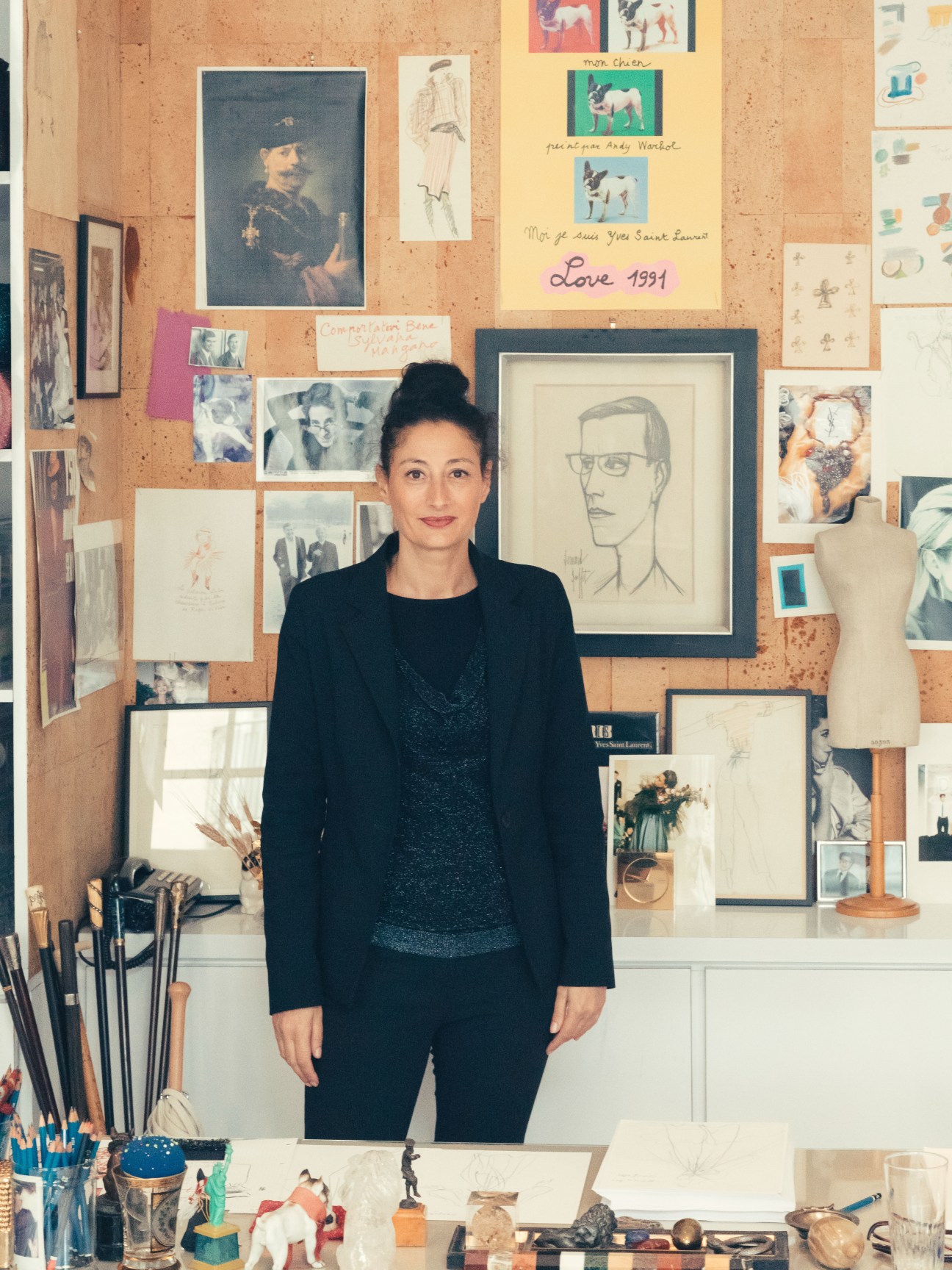 Aurélie Samuel, head of collections at Musée Yves Saint Laurent, stands in front of a cork board displaying photographs, sketches and personal mementos.