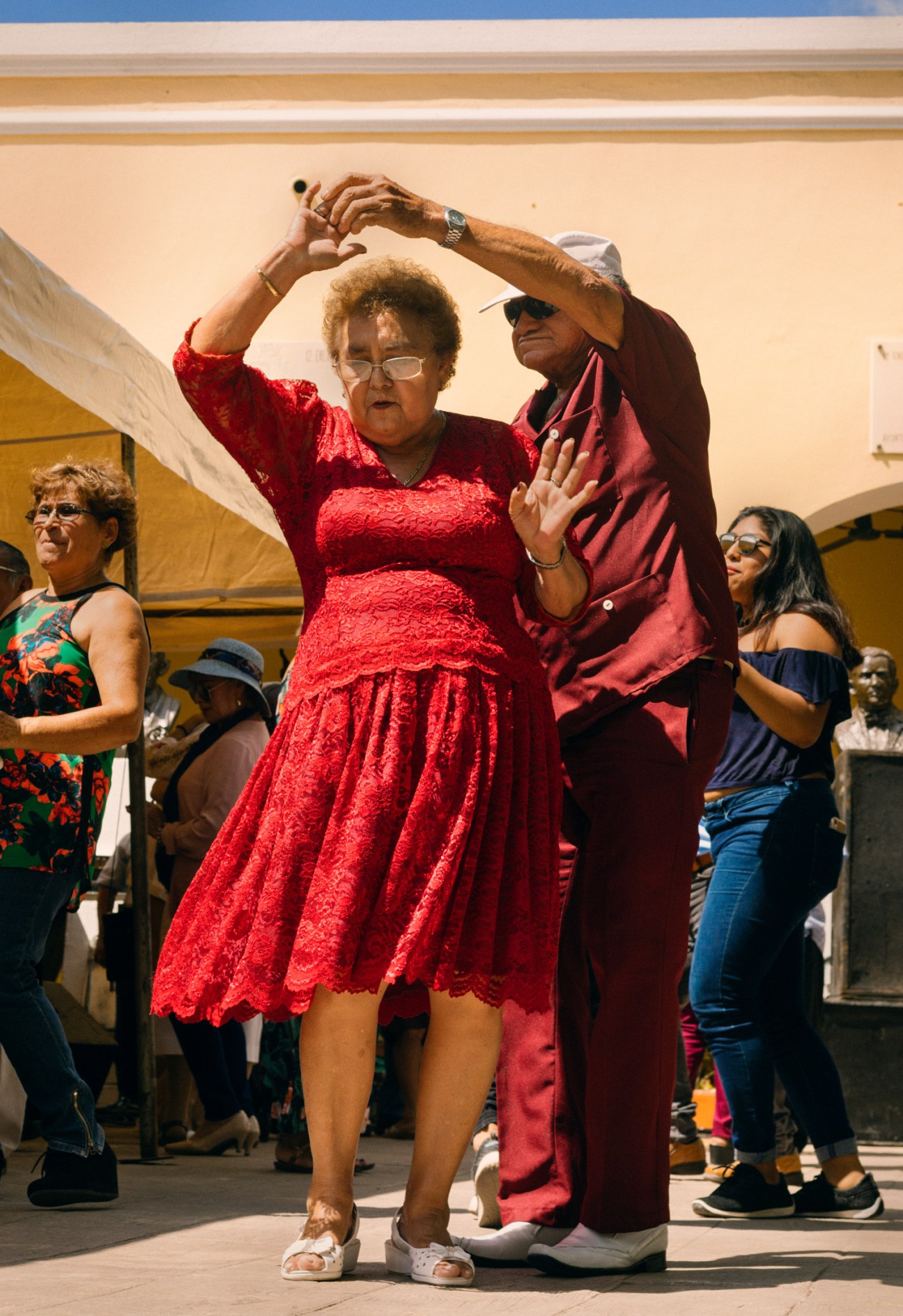 Couple dancing in red clothing at an outdoor concert in Santa Lucía Park, Mérida.