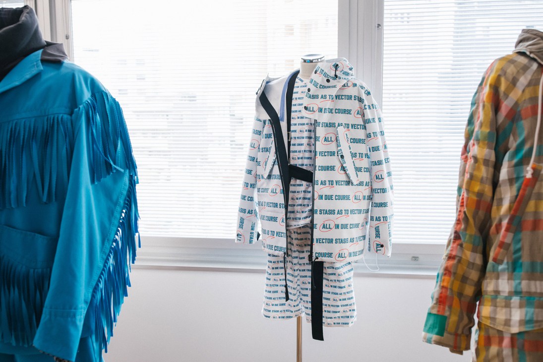 Sacai spring/summer 2018 menswear pieces on display, including a text-printed jacket with Lawrence Weiner's words.