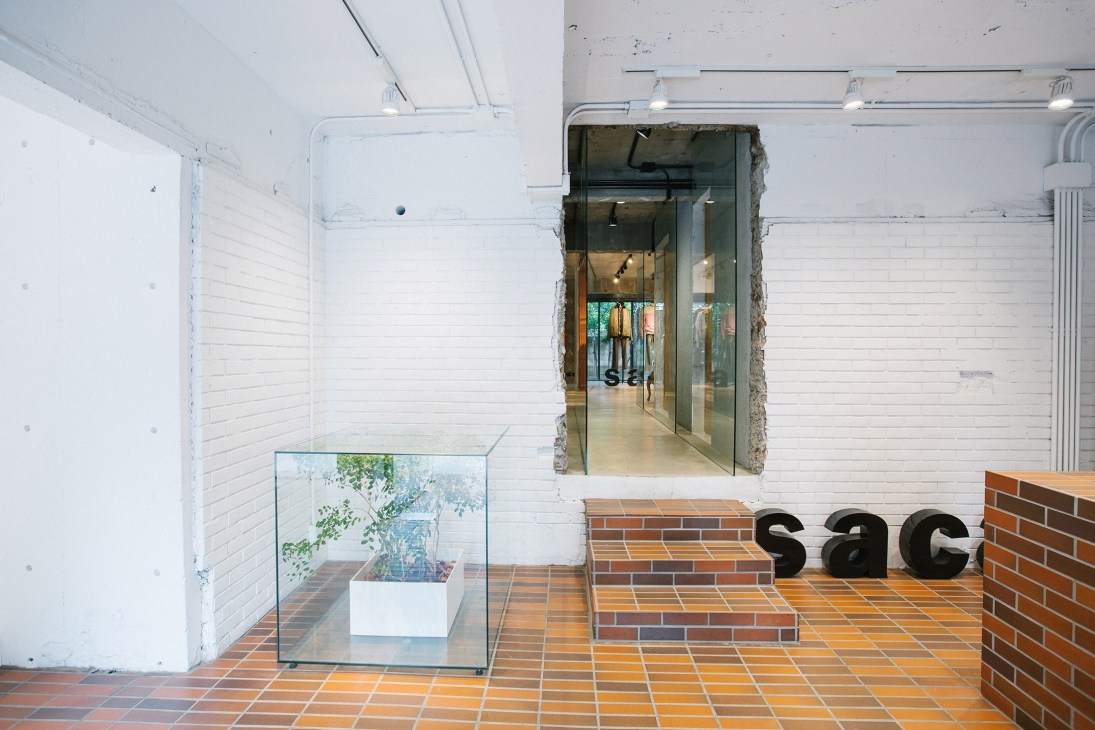 Sacai flagship store interior with mixed materials including white brick, terracotta tiles, and exposed concrete designed by architect Sou Fujimoto.