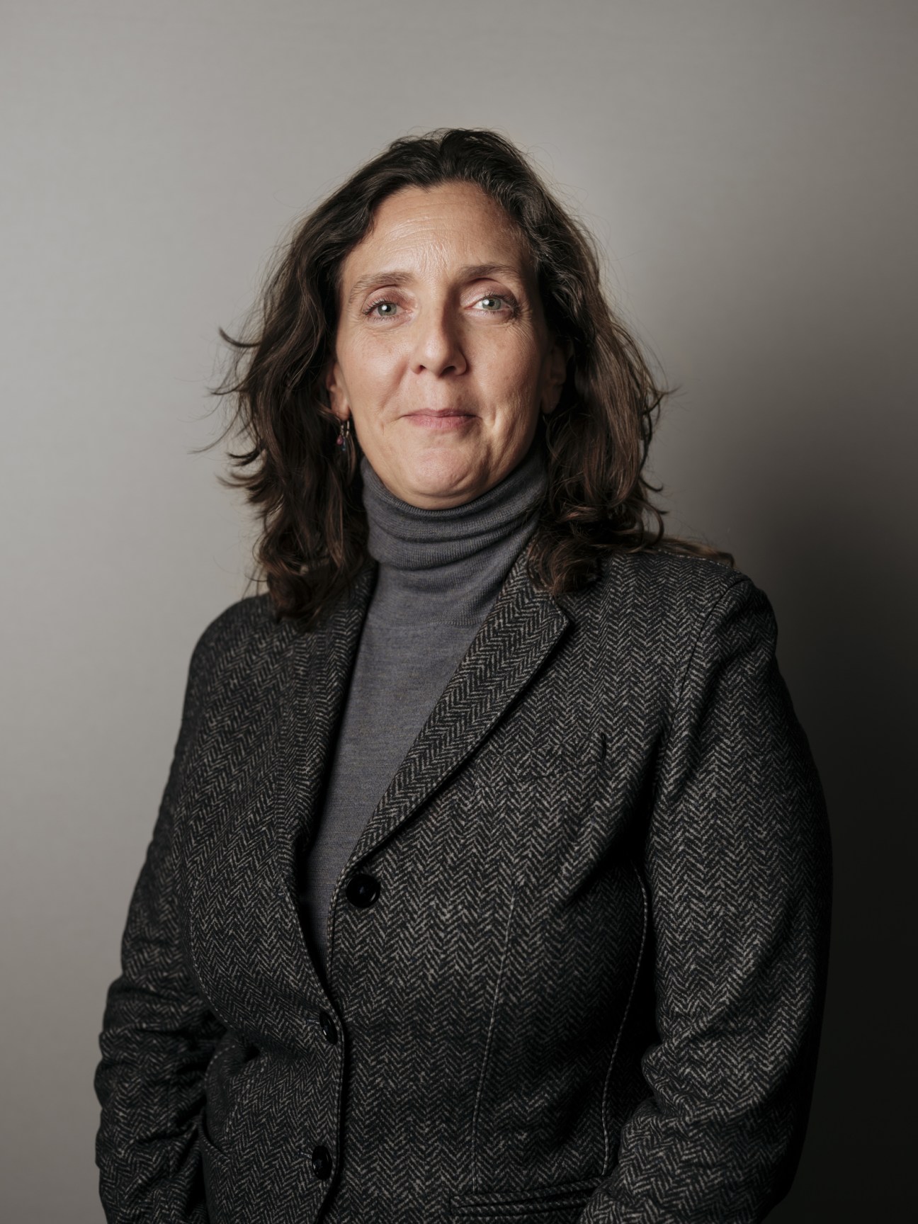Portrait of Vanessa Monestel, CEO of Laurent Ferrier, wearing a charcoal herringbone blazer and gray turtleneck.