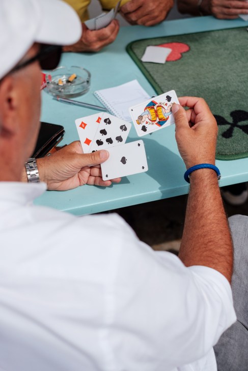 Men playing cards at a table at the Bains des Pâquis public baths in Geneva.