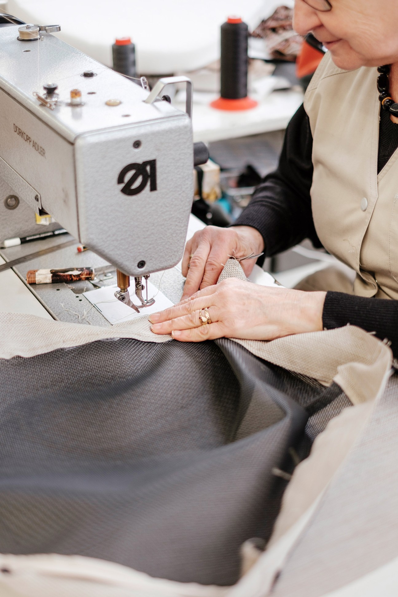 Worker sewing weatherproof fabric on an industrial sewing machine at Lafuma Mobilier factory.