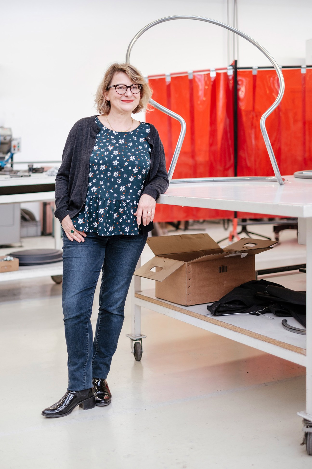Sylvie Angeloni, head of product and marketing at Lafuma Mobilier, stands in the factory with a chair frame behind her.
