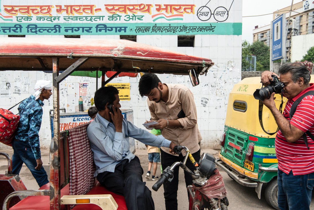 Delhi city reporter Paras Singh investigating electric rickshaws running on dirty fuel at a street location.