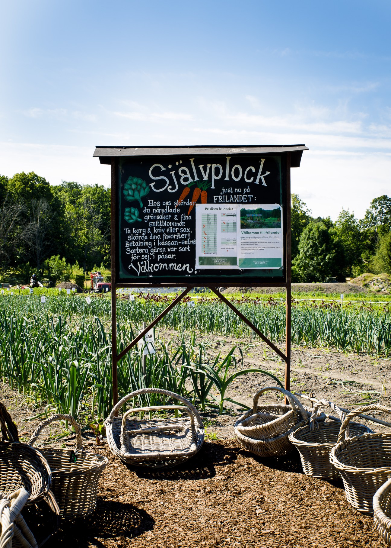 Information board showing self-pick garden guidelines with wicker baskets scattered on ground below