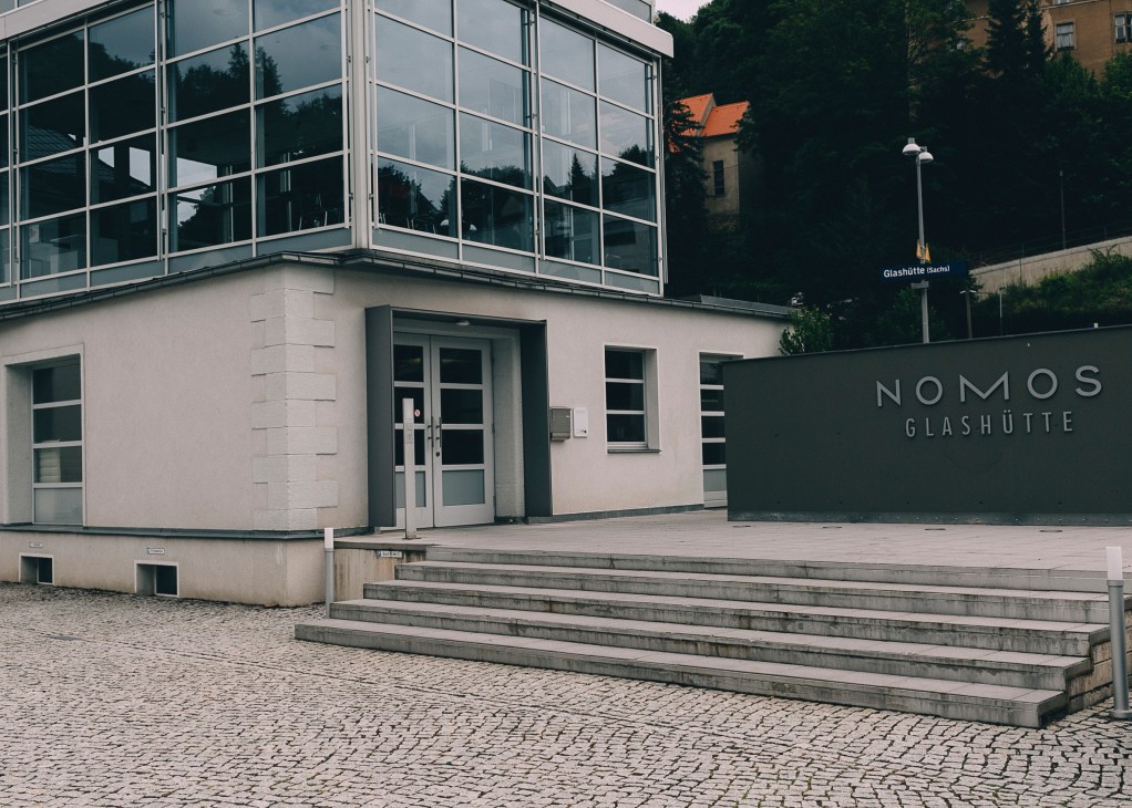Nomos Glashütte storefront with modernist architecture and signage in Glashütte, Germany.
