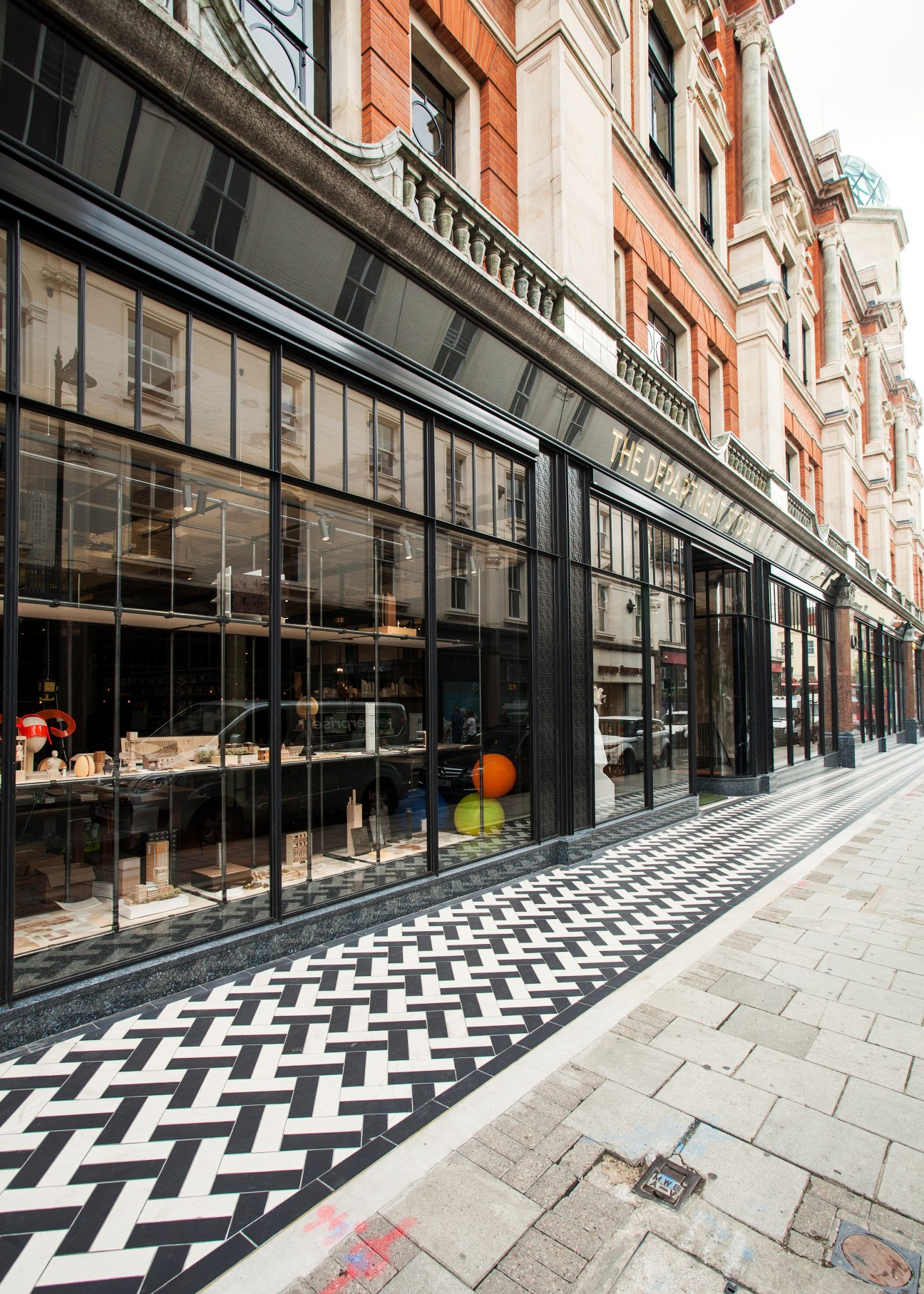 The Department Store's street frontage with black-framed windows, geometric patterned flooring, and Victorian brick facade above.