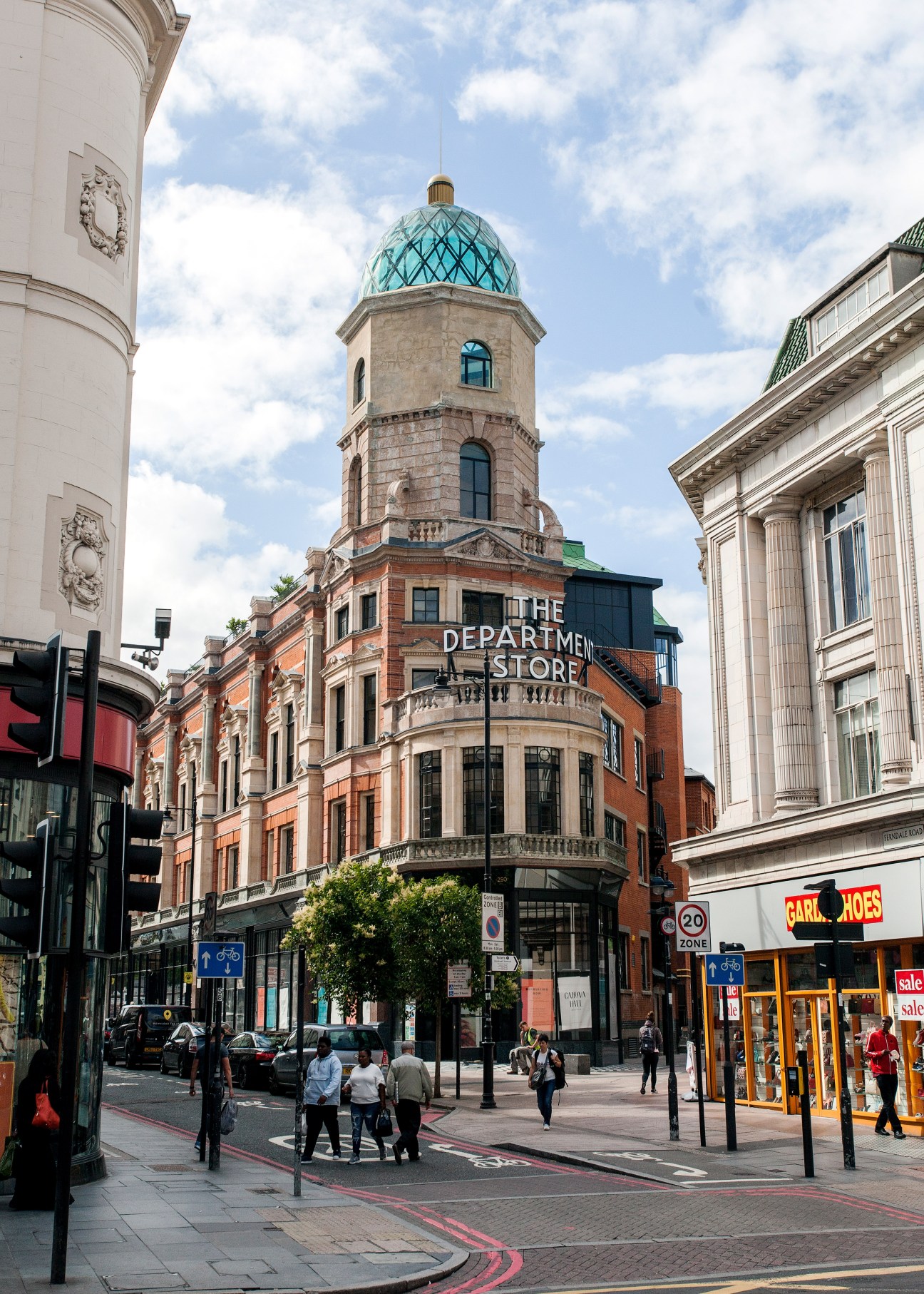 Brixton's Department Store building with distinctive turquoise dome and red brick facade on busy street