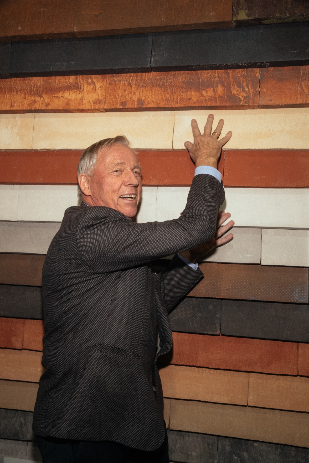 Brick dealer Christian A Petersen gesturing with his hand against a multicolored brick wall display