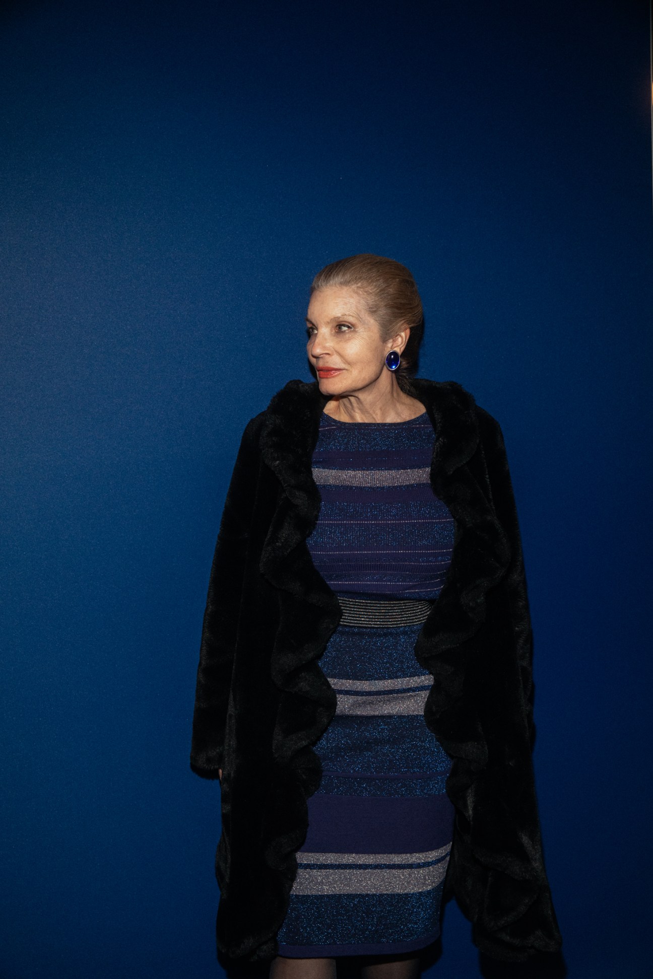 Attendee Silvia Klin wearing a striped blue dress and black coat at the Swissbau fair