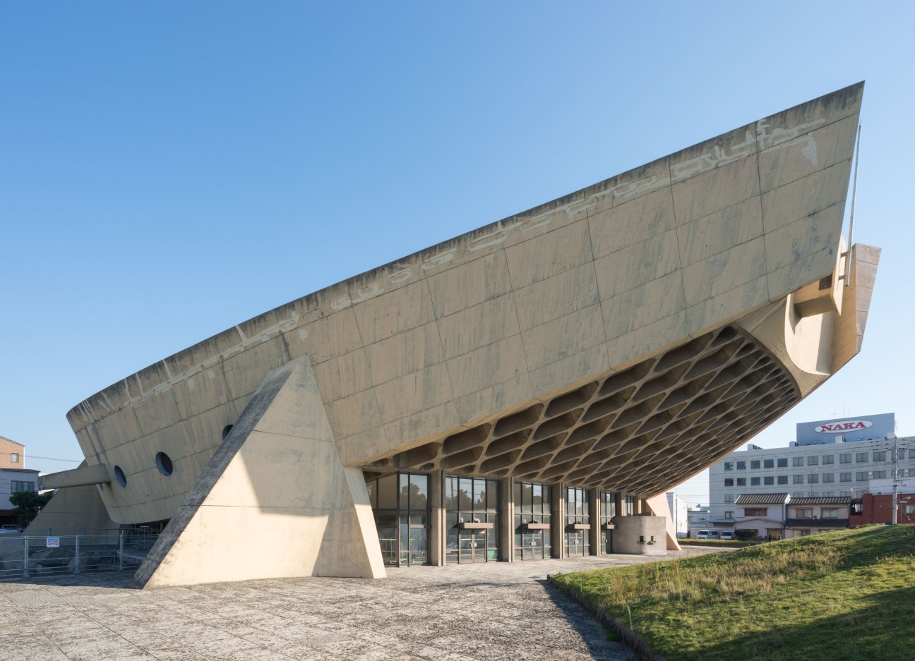 Kagawa Prefectural Gymnasium, a brutalist concrete structure with a swooping roof resembling a boat hull, designed by Kenzo Tange in 1964.