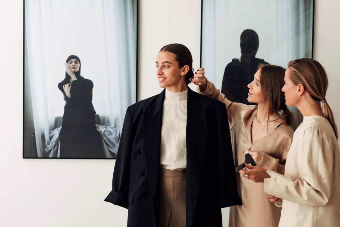 Pia Nordskaug and Celine Aagaard dressing a model in a neutral-toned blazer and sweater.