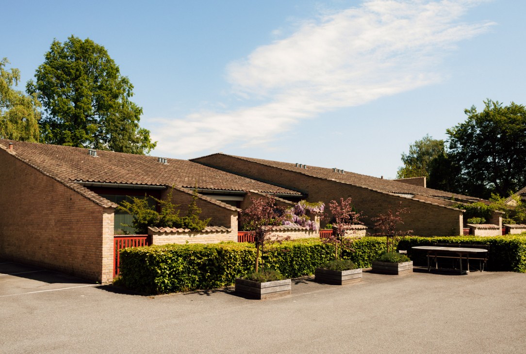 Brick residential buildings with sloped roofs and private courtyards at the Fredensborg Houses designed by Jørn Utzon.