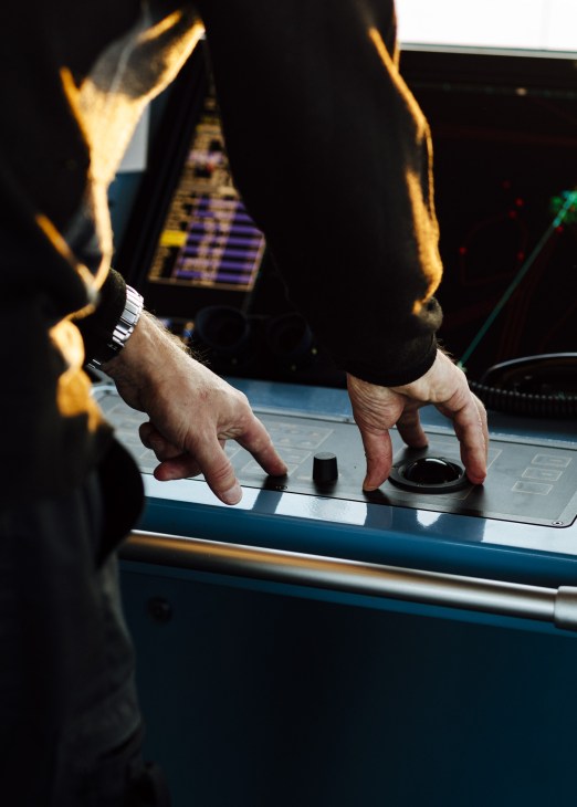 Hands operating control panel on the bridge of the icebreaker Kontio.