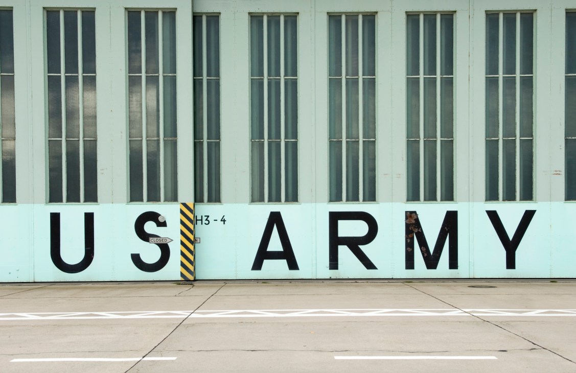 Tempelhof hangar door with painted 'US ARMY' text and narrow windows above, remnant of Berlin occupation era.