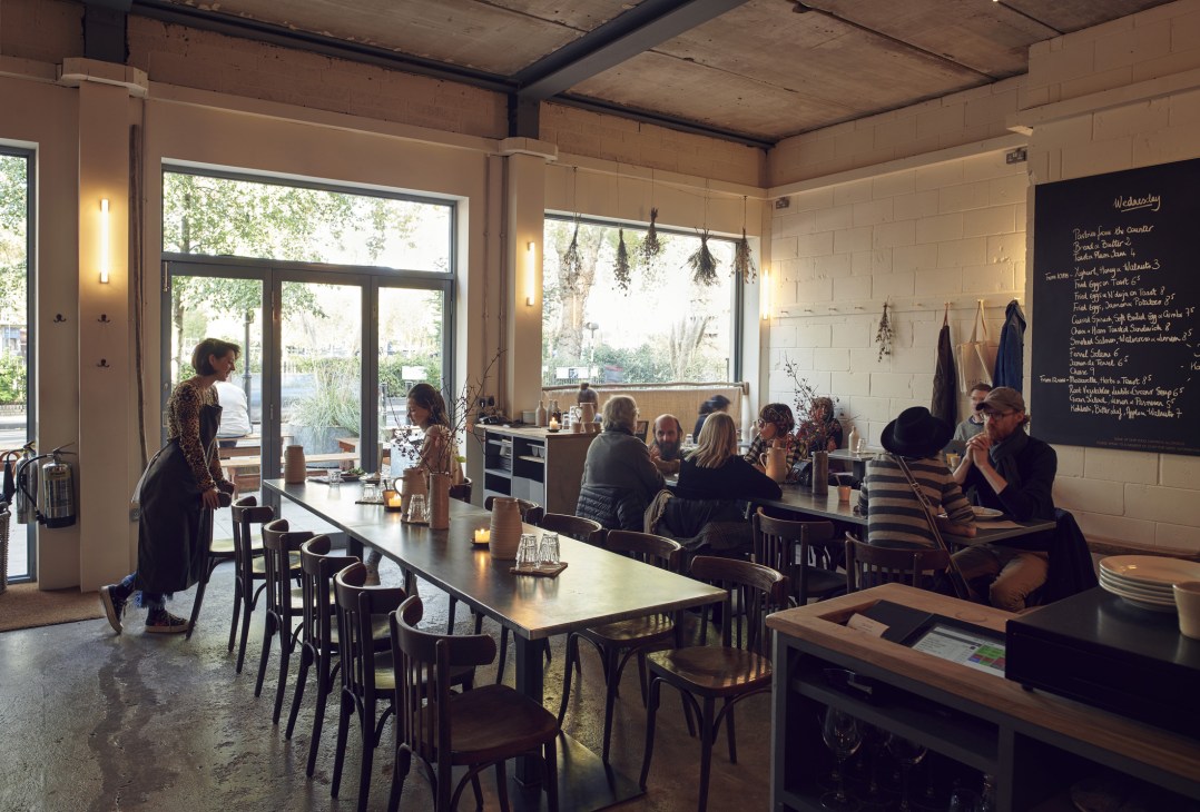 Interior of Jolene restaurant and bakery on Newington Green in London with customers seated at tables.