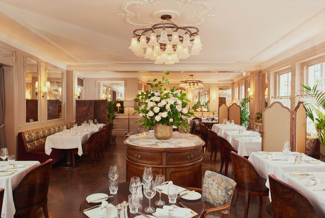 Formal dining room at Kettner's with white tablecloths, ornate ceiling, and period furnishings.