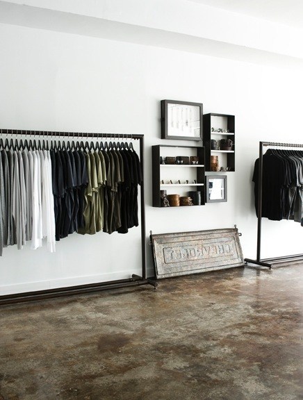 Interior of Mortar menswear boutique showing clothing racks, wall shelving, and vintage sewing machine display.