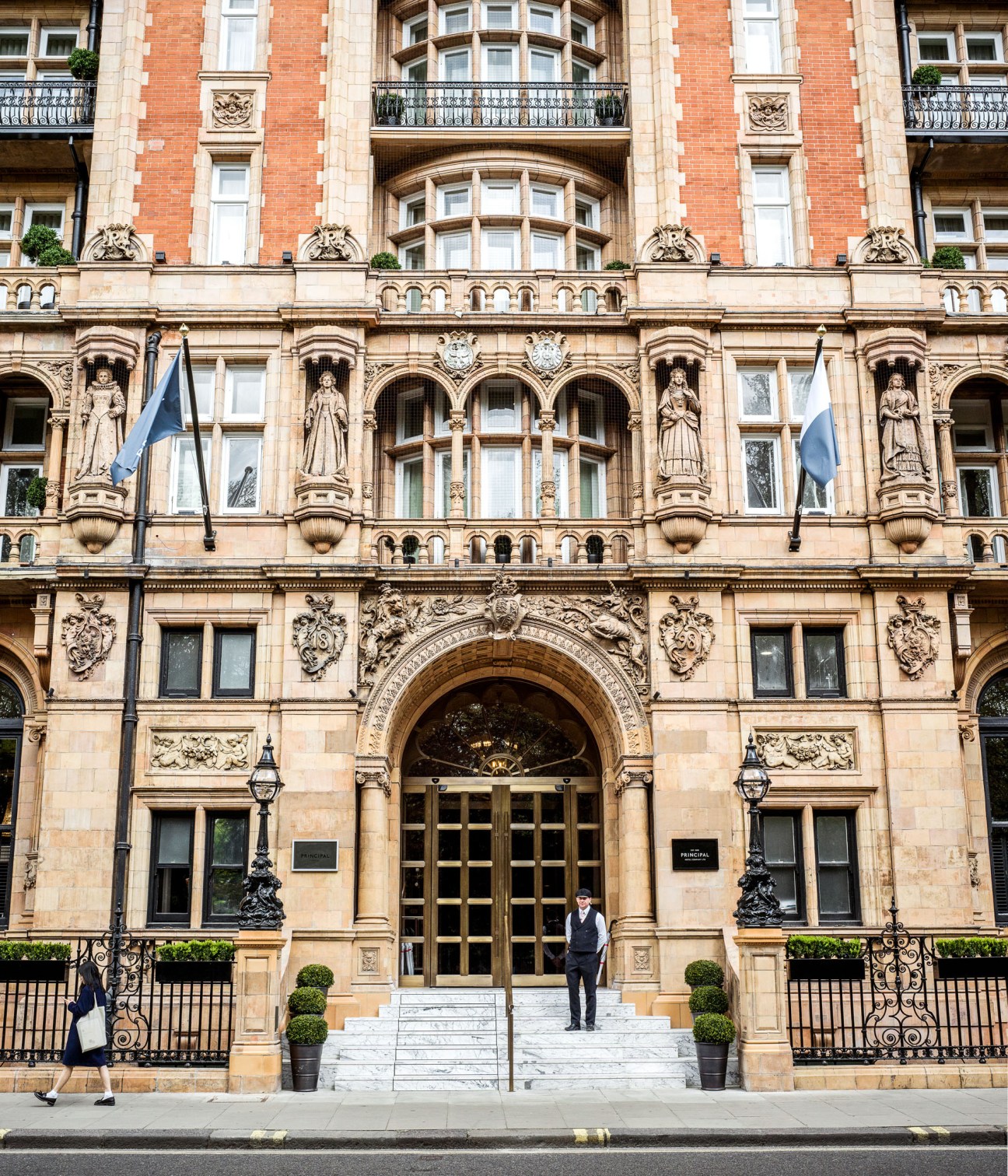 The Principal hotel's ornate 19th-century stone and terracotta façade with arched entrance and decorative statuary in London's Bloomsbury.